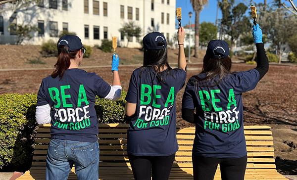 Volunteer employees painting a bench